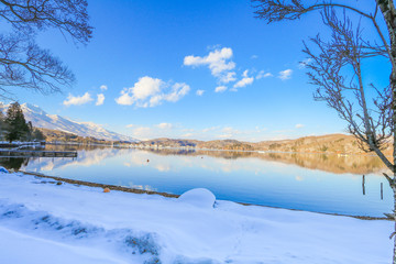 Beautiful fresh snow in winter around the mountains  Lake ,and tree  with blue sky  background, Nagano Prefecture, Japan.