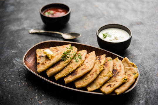 Aloo Paratha / Indian Potato stuffed Flatbread. Served with fresh curd and tomato ketchup. selective focus