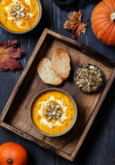 Vegetarian pumpkin cream soup. Autumnal pumpkin soup. Home made pumpkin cream soup decorated with cream, seeds, bread