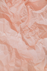 Pastel peachy crumpled paper texture.