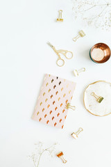 Gold styled home office desk with notebook, scissors and clips on white background. Flat lay, top view blog concept.