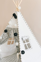 Interior room for a child. Tent for game. Wigwam with a garland of cotton balls. White and grey