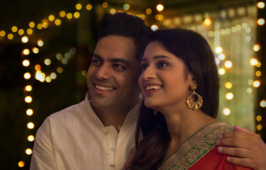 young couple smiling while standing together on the occasion of Diwali