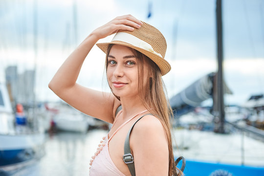 beautiful young woman travel girl on the background of a sea pier with boats and yachts, travel concept