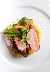 Duck fillet with figs and carrot puree on a white plate