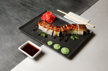 fried roll with eel on a black plate