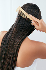 Hair Care. Beautiful Woman Brushing Wet Long Hair After Bath 