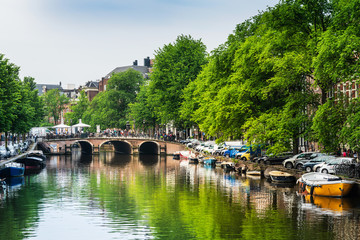 Amsterdam, Netherlands - May 23, 2018: Beautiful view of Amsterdam canals with bridge and typical dutch houses. Amsterdam, Netherlands