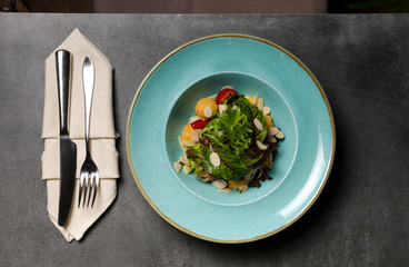 Salad with strawberries and mozzarella cheese on a blue plate