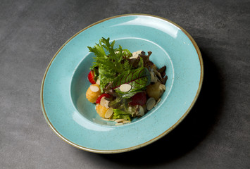 Salad with strawberries and mozzarella cheese on a blue plate