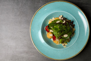 Salad with strawberries and mozzarella cheese on a blue plate