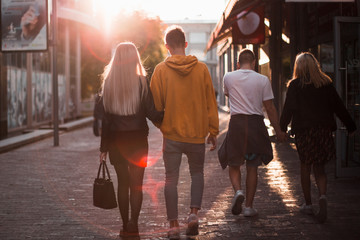 People walk in streets of at sunset