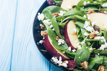 Autumn spinach salad with apple , cheese , walnut and dried cranberry