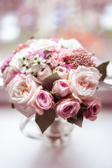 Delicate wedding bouquet stands in a circle on the window.
