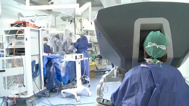 The doctor uses a surgical robot - a back view
Surgery room