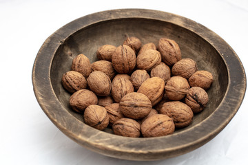 Walnuts in  old handmade wooden bowl