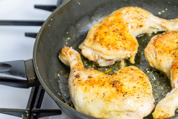 Fry chicken legs in a pan with spices.