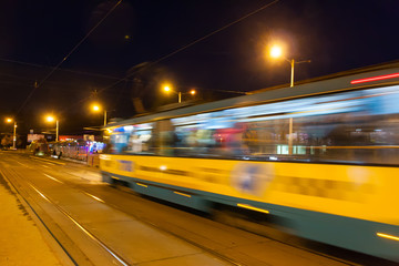 Naklejka na ściany i meble The motion blurred tram in the evening.