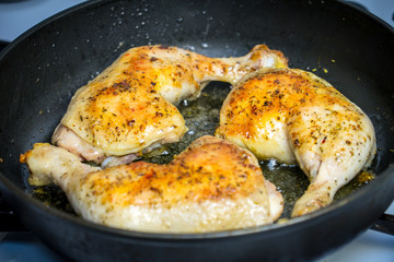 Fry chicken legs in a pan with spices.