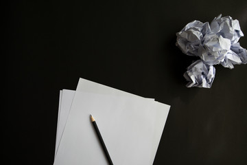 Paper and pencil, Placed on a black background, There is a crumpled paper on the right, copy-space, Restart again concept.