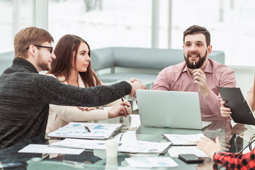 handshake financial partners and business team in the workplace