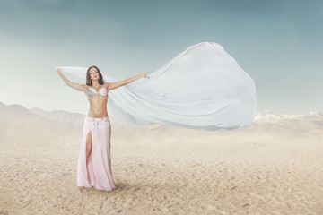 Beautiful young woman dancing belly dance outdoor