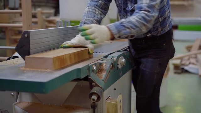 employees of wood processing dub workpiece on the machine planer