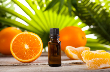 Orange Essential Oil on green leaves background