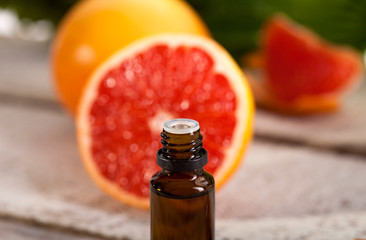 Grapefruit Essential Oil on green leaves background