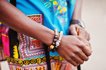 Close up hands of african man in africa traditional shirt with bracelets.