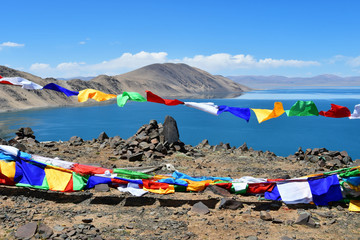 Tibet, Buddhist flags with mantras on Nam-Tso lake background (Nam Tso) on a cloudy summer day