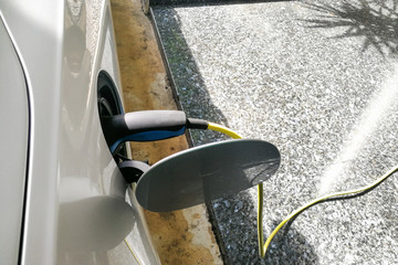 Fototapeta na wymiar Closeup of electric hybrid car being charged with socket