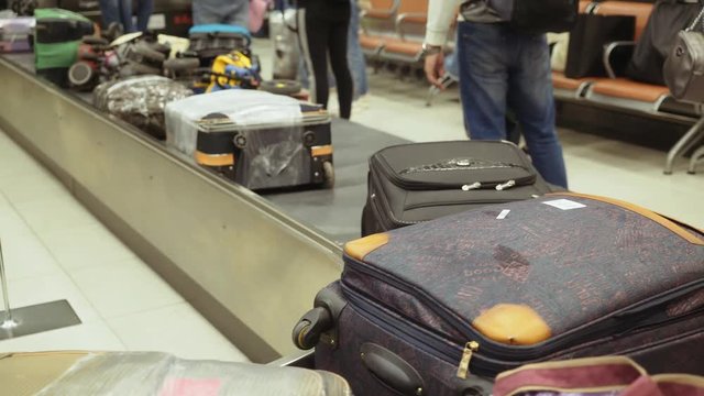 Bags, suitcases rotating on a conveyor belt at the airport. Baggage claim.