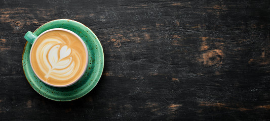 Cappuccino. Coffee with milk. On a black wooden background. Top view. Free copy space.