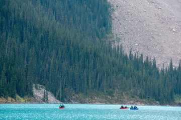 Fototapeta na wymiar Three small canoes on blue glacial lake