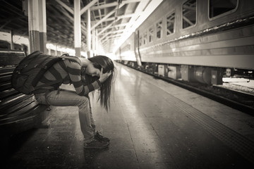 young traveler woman with backpack depressed and stressed while waiting for train