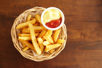 French fries in a basket are placed on the table.
