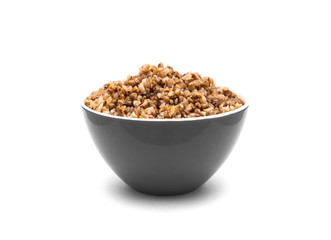 Dry buckwheat in grey color ceramic bowl isolated on white