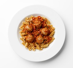 Meatballs in a tomato sause with paste twists on a white plate.