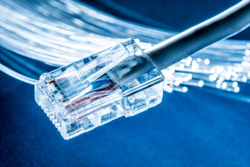 Network cable and optical fibers with lights in the ends at the background.