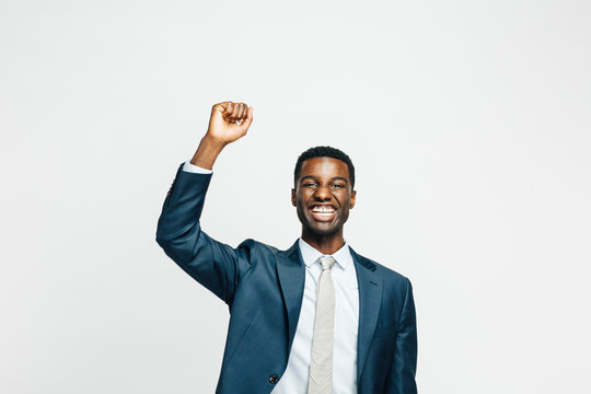 Portrait Of A Happy Young Man In Business Suit With Fist  Up, Isolated On White Studio Background