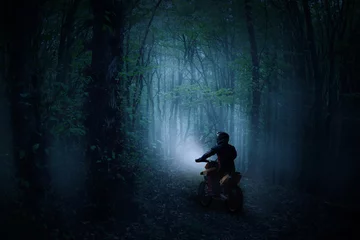 Gordijnen A rider on a motorcycle in a haunted misty forest © Jitka Svetnickova