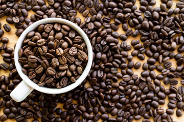 Close up of white coffee cup full of coffee beans background with copy space