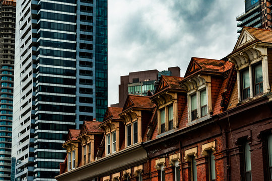 The Tops of Old Brick Buildings Surrounded by Skyscrapers in Downtown Toronto