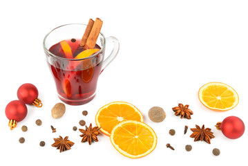 Hot red mulled wine isolated on white background with christmas spices, orange slice, anise and cinnamon sticks, close up.
