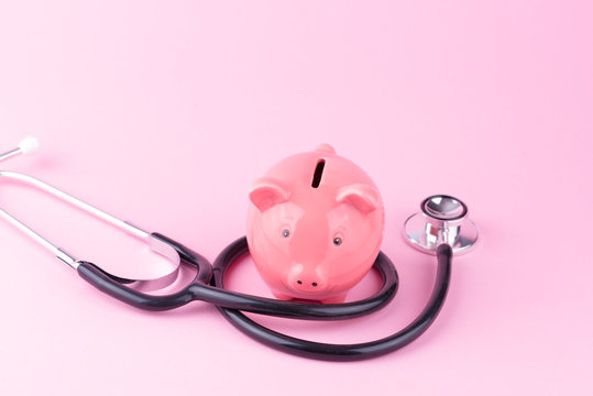 Sparschwein mit einem Stethoskop vor rosa Hintergrund