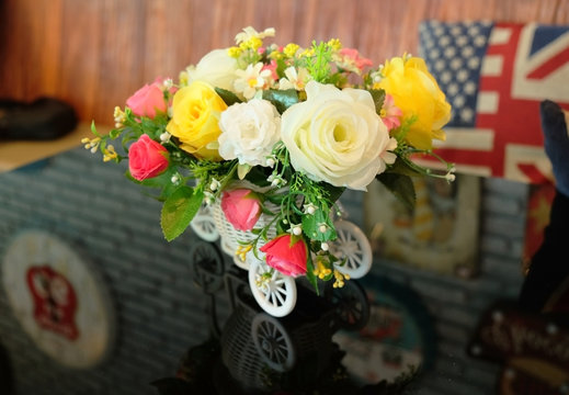 Toy car and a beautiful bouquet of plastic flowers.