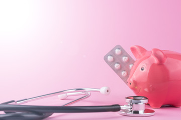 Sparschwein mit Arzt Stethoskop in einer Arztpraxis vor rosa Hintergrund