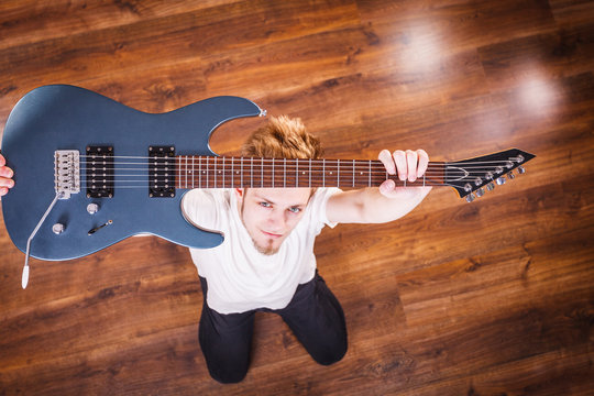 Proud man raising his electric guitar