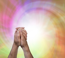 The power of prayer - male hands in prayer position with a large white spiralling vortex flowing...